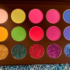 Side view of vegan cruelty-free eye shadow palette showcasing shimmering teal and silver glitter shades in compact case