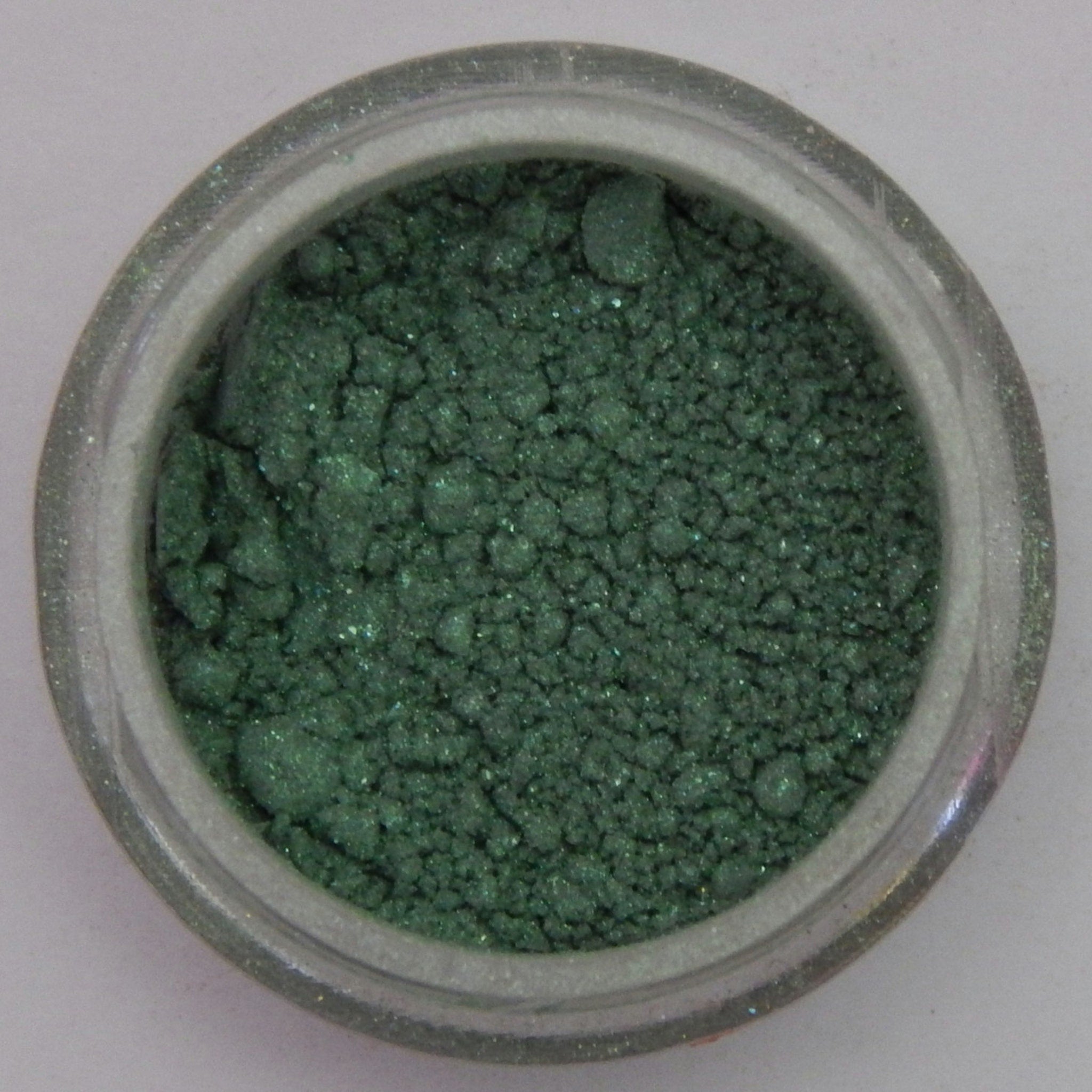 Close-up of shimmery Fairy Frolic mineral eyeshadow with soft pink and gold flecks in compact case