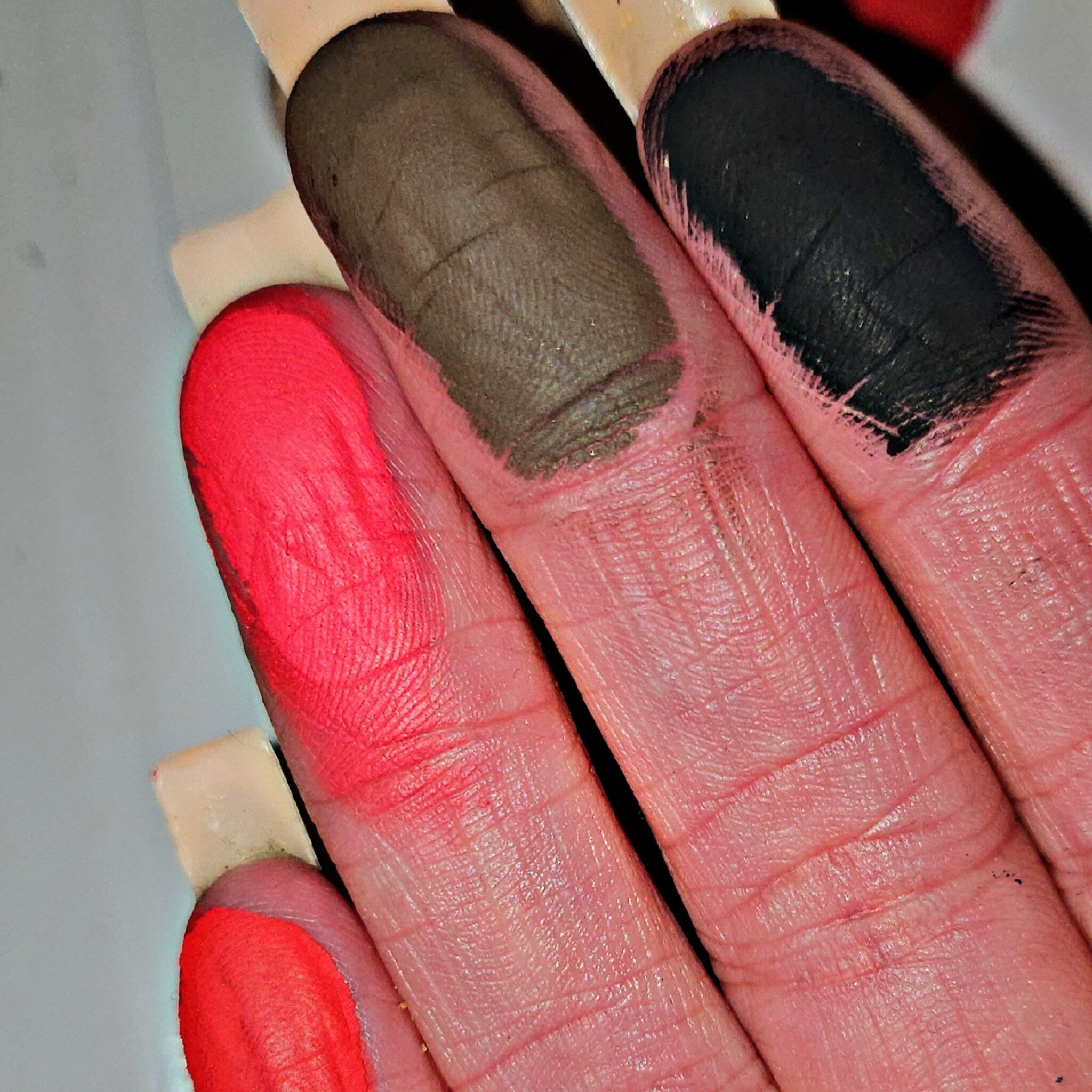 Close-up of a hand applying shimmery bronze eye shadow from the Boudica palette with a fluffy brush