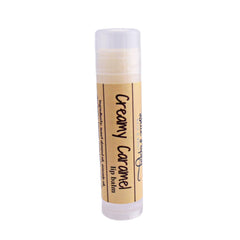 Lip balm tube with beige label, Creamy Caramel text, and BluePoppyBath logo