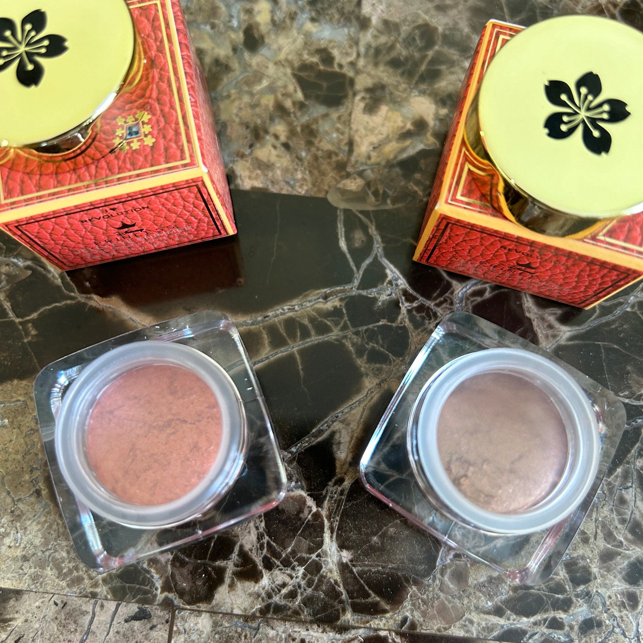 Eye shimmer with red patterned box, gold lid, and flower design on top