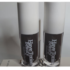 Lip gloss bottles with white caps, dark brown liquid, and Haye Tonise Beauty text visible