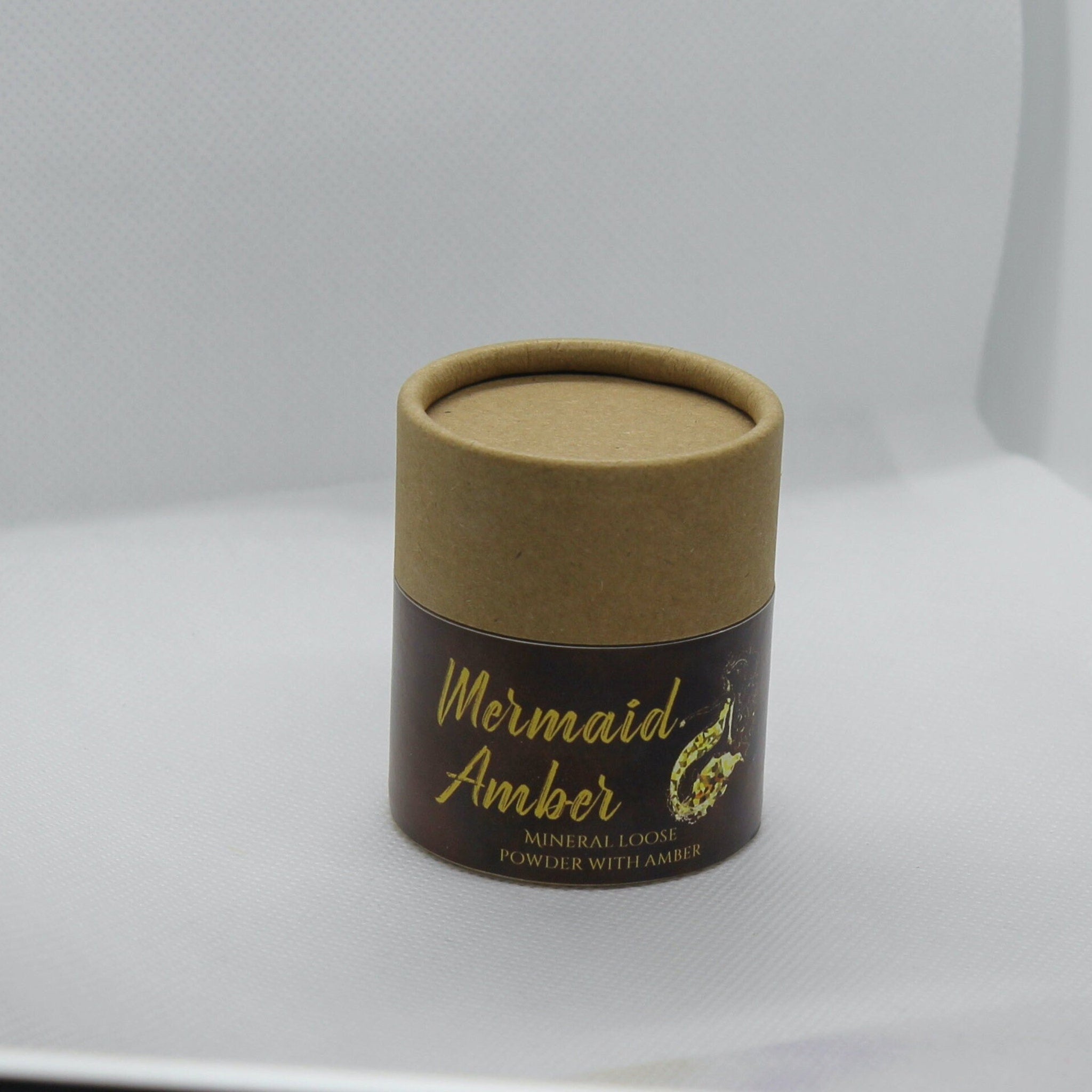 Face powder container, brown cardboard, Mermaid Amber text, cylindrical shape