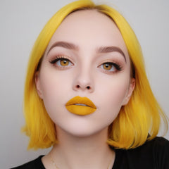 Lip gloss, matte yellow lip color on a person, with matching yellow hair