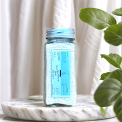 Powder Face Cleanser, clear glass jar with light blue powder, Nizzynaturals label visible on jar, on marble base