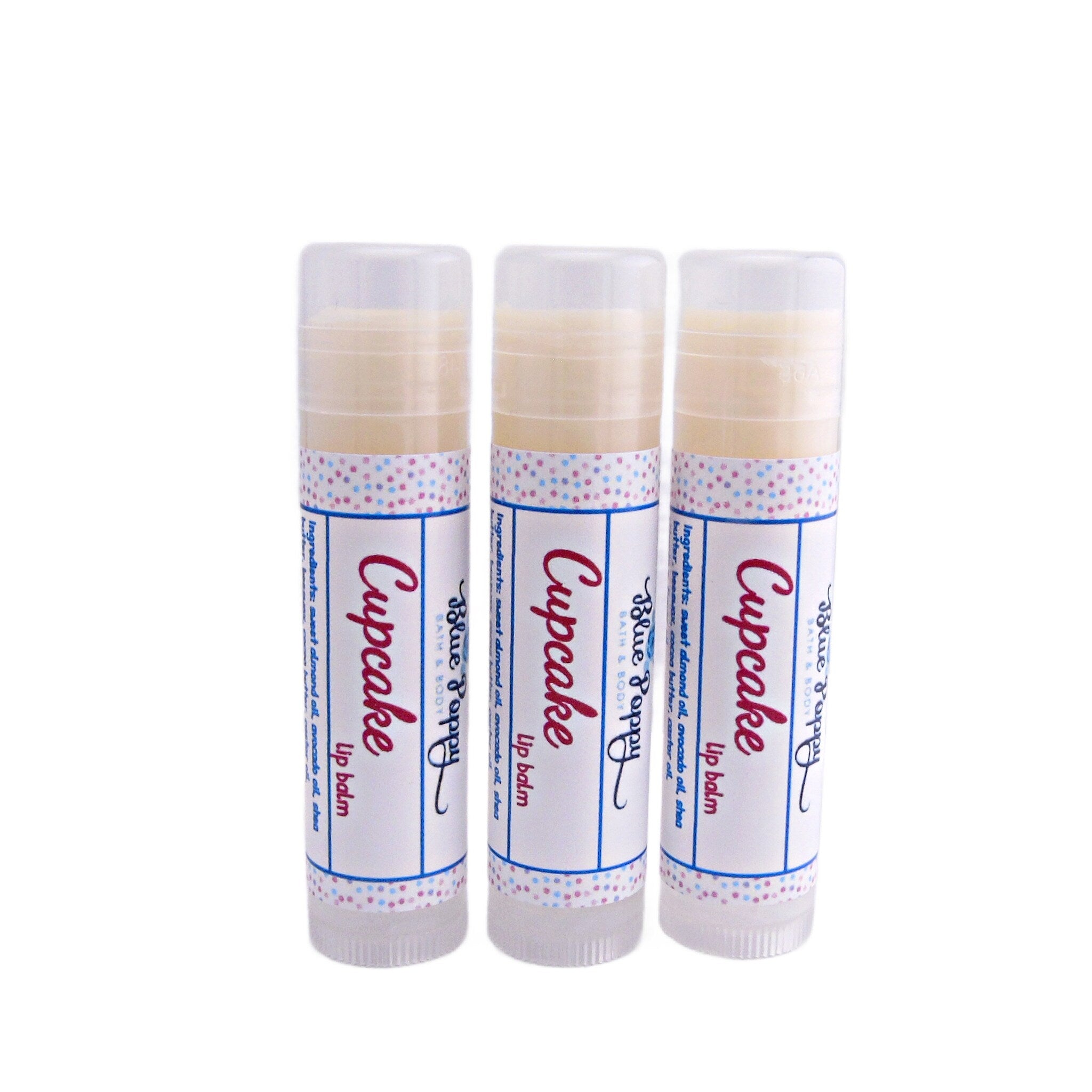 Lip balm tubes with white, blue, and pink polka dot label and "Cupcake" text, Blue Poppy brand visible