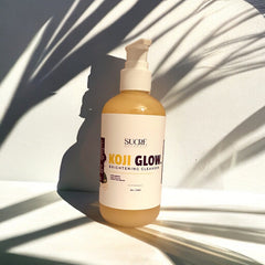 Brightening cleanser bottle with white and beige label, clear liquid, and white pump top, Sucre Naturals brand