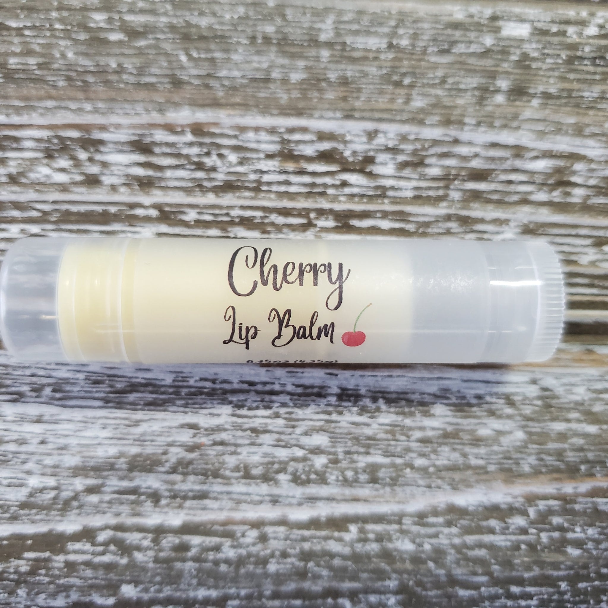 Cherry lip balm in clear plastic tube with cream colored balm, Griffin Lily Designs label