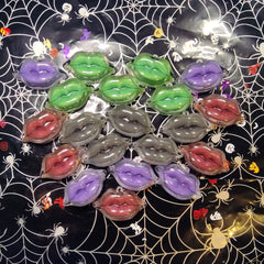 Lip-shaped ornaments in various colors, clear plastic, on spiderweb background