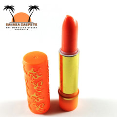 Lipstick tube with orange and gold colors, floral pattern on the lid, and open for use