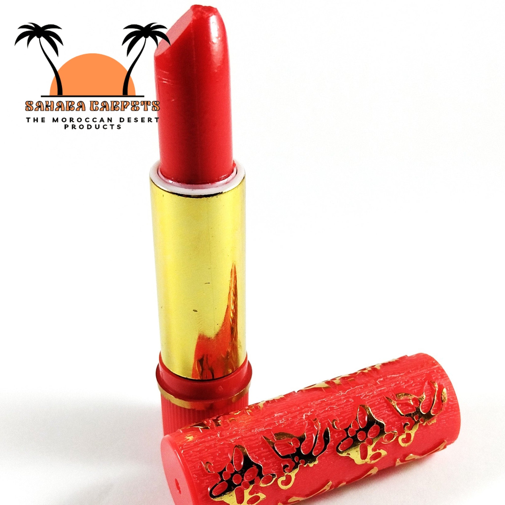 Red lipstick with gold tube and patterned red cap on white background