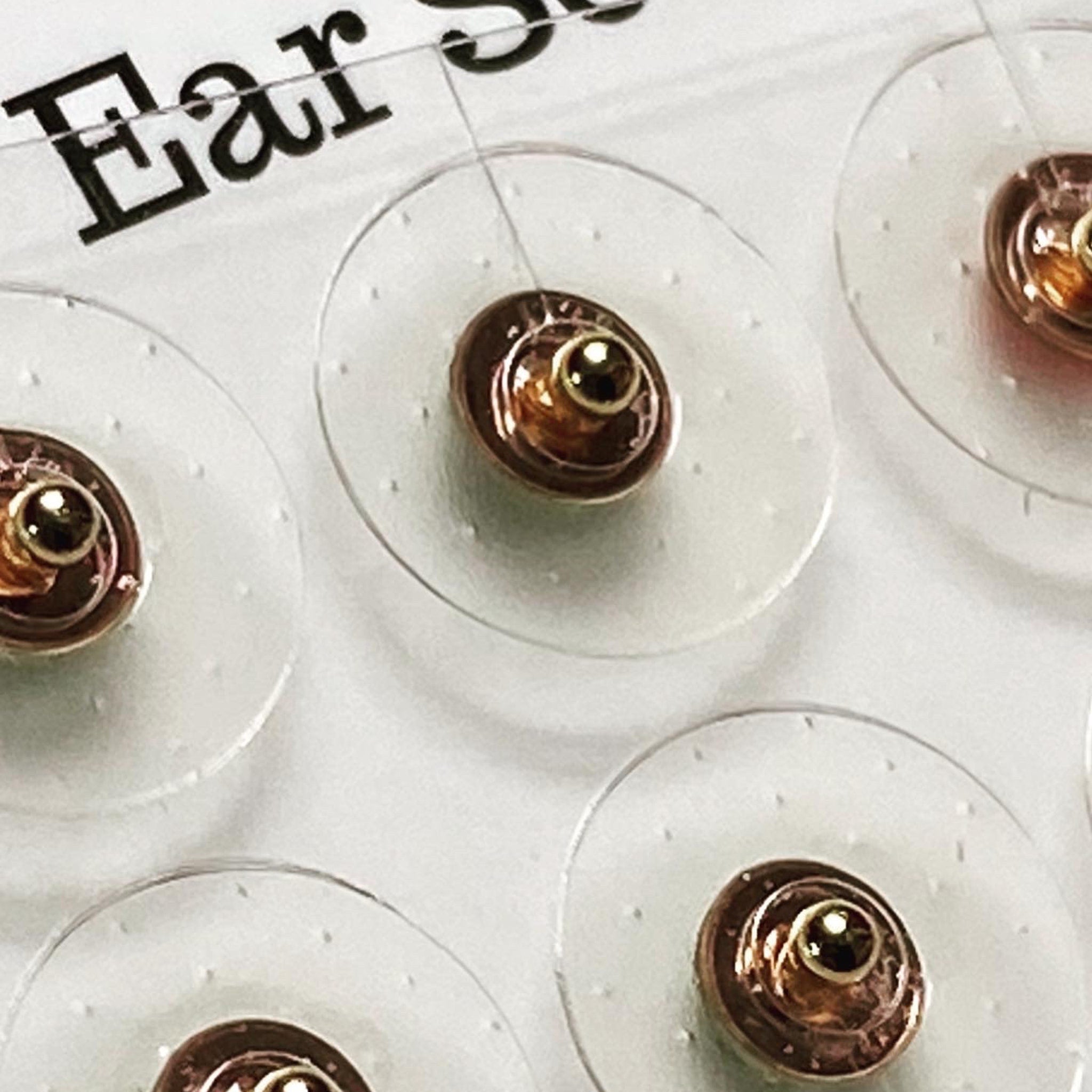 Earring backings with clear plastic, gold metal, and small round shape for jewelry use