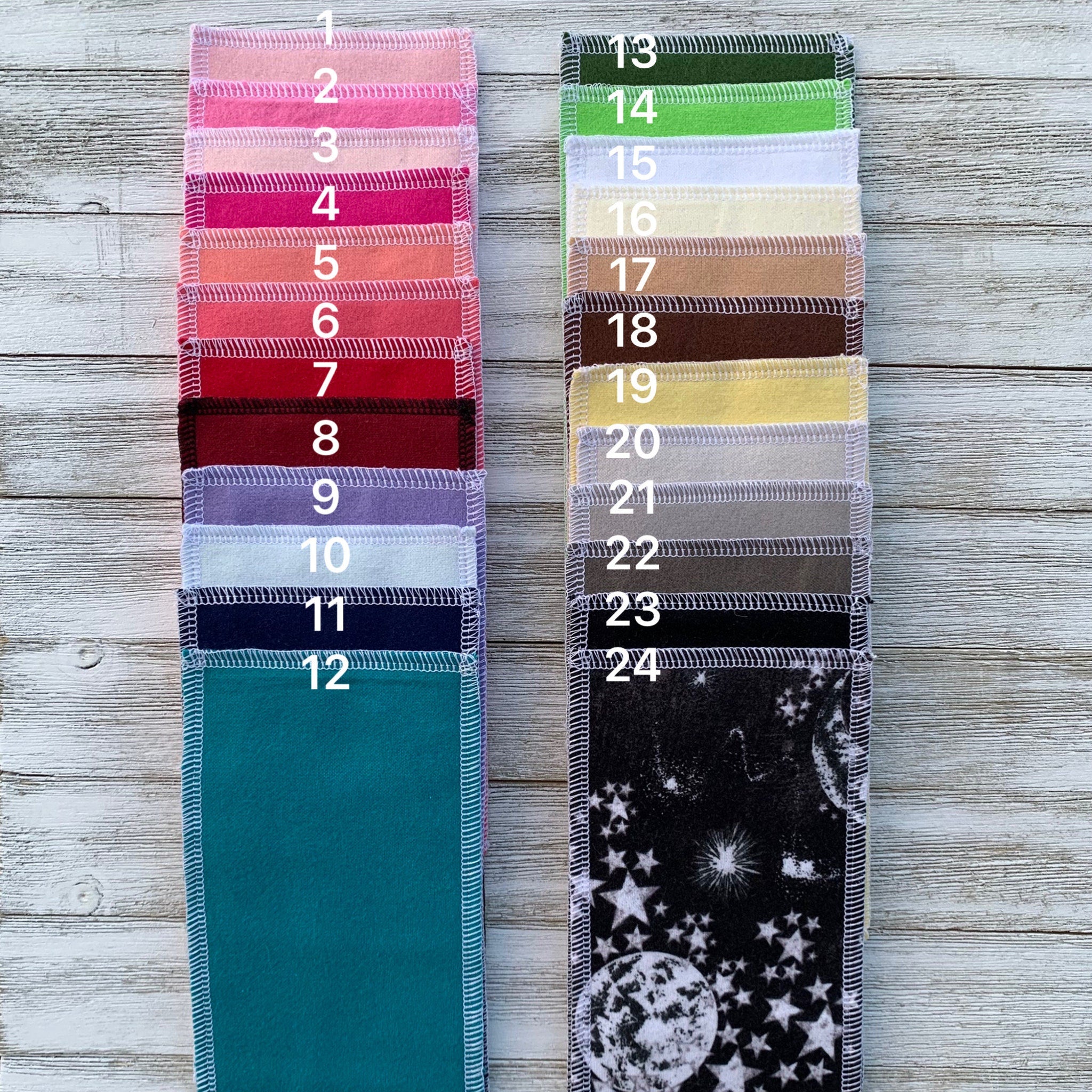 Cloth pads in various solid colors and a celestial pattern, with white stitching detail