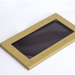 Open magnetic palette displaying 32 golden glitter eyeshadow pans in multichrome shades with reflective sparkle