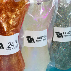 Lip gloss base with gold glitter, clear packaging, and brand labels