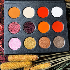Close-up of fingers applying shimmery bronze eyeshadow with a blending brush on eyelid