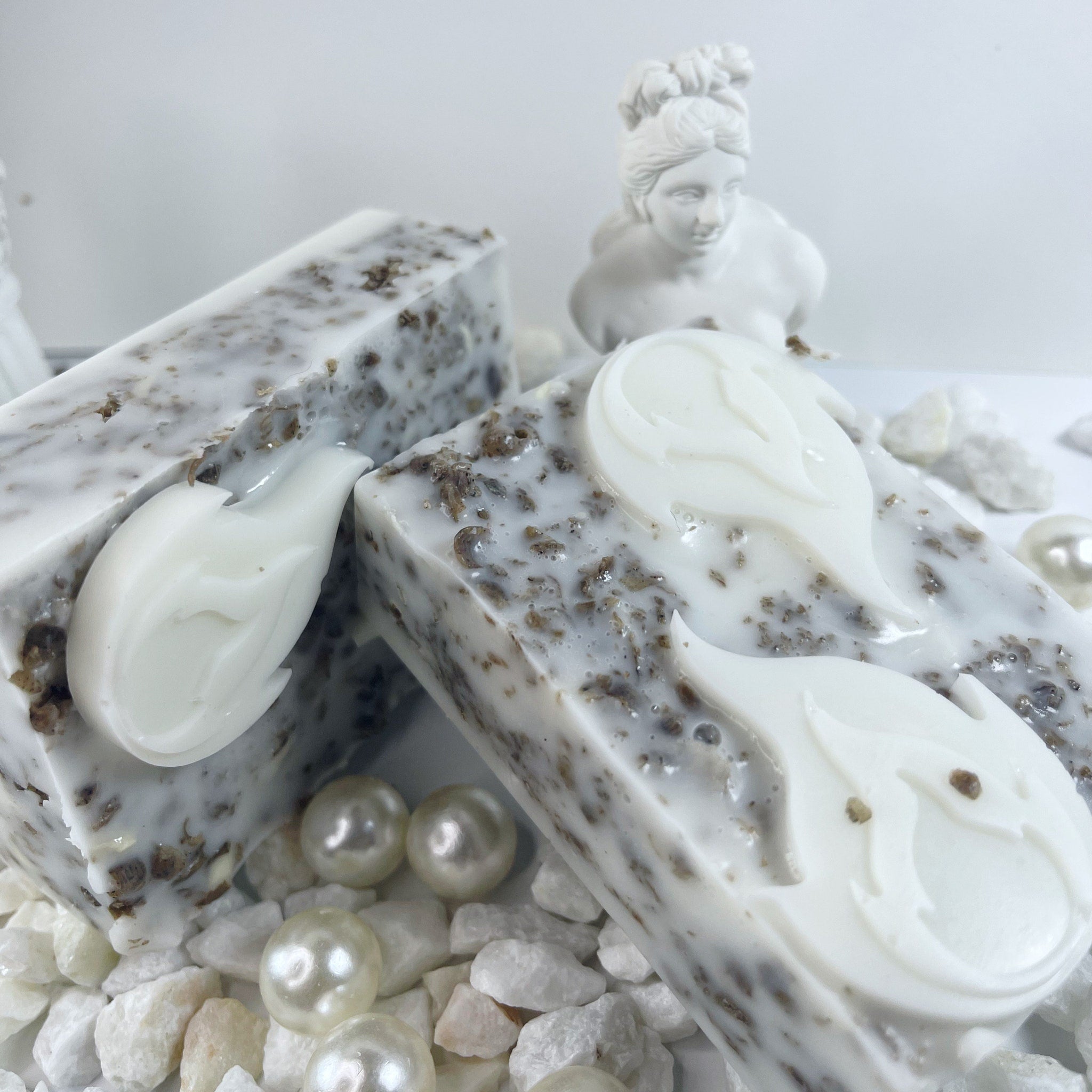 Soap bars with white and brown speckled pattern, white floral design, and decorative pearls