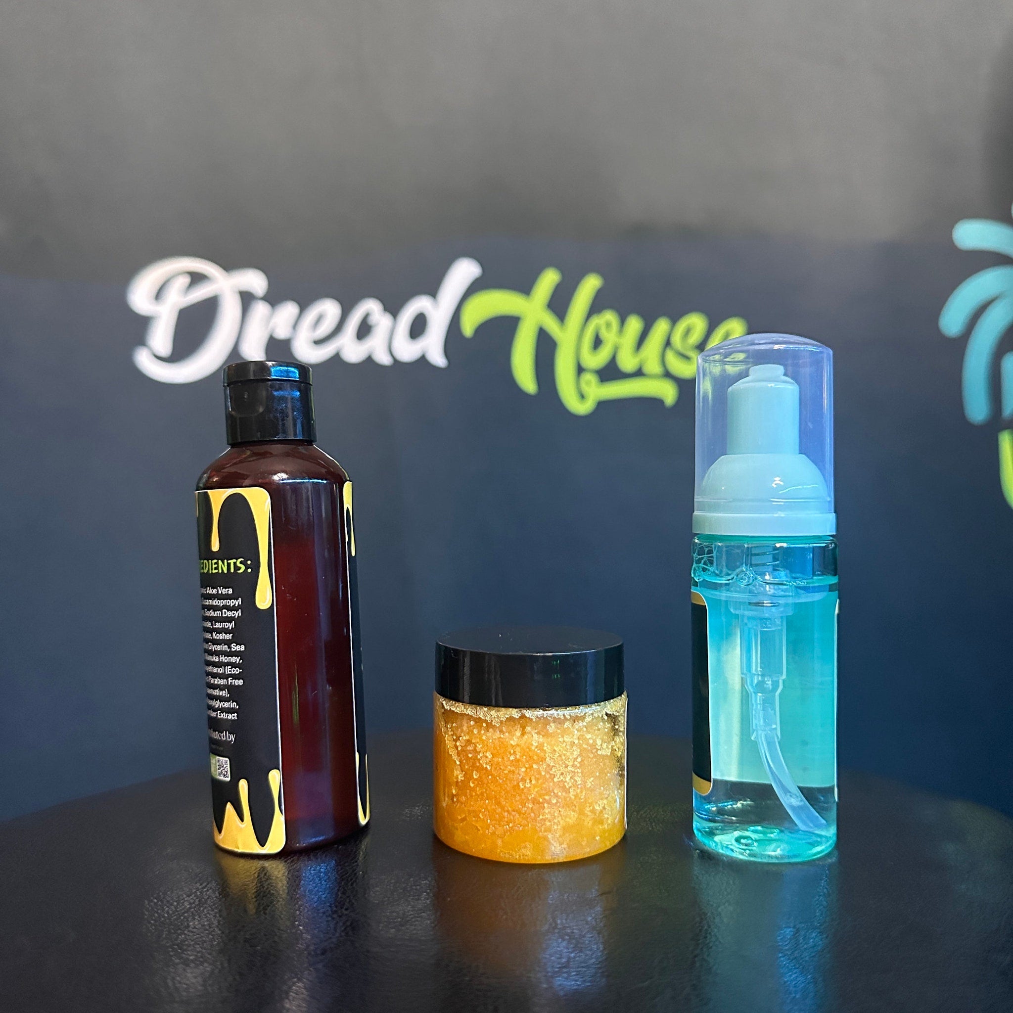 Hair care products with brown, black, and clear bottles, Dread House branding visible, on a black surface