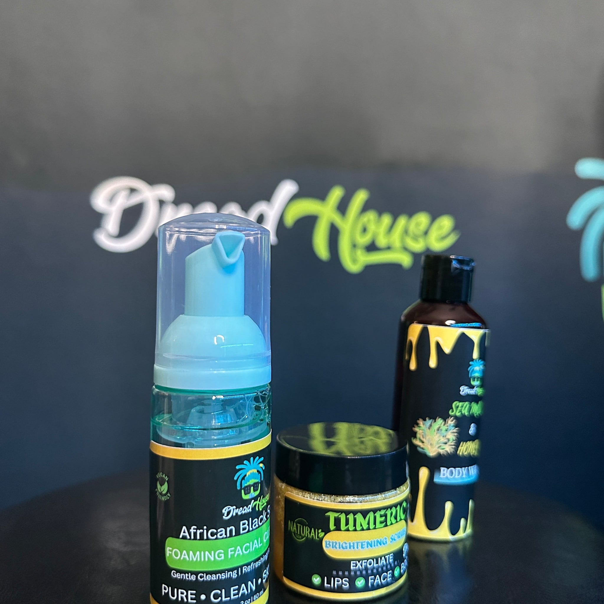 Facial cleanser bottles with blue, black, and yellow labels, Dread House brand products, for skin care