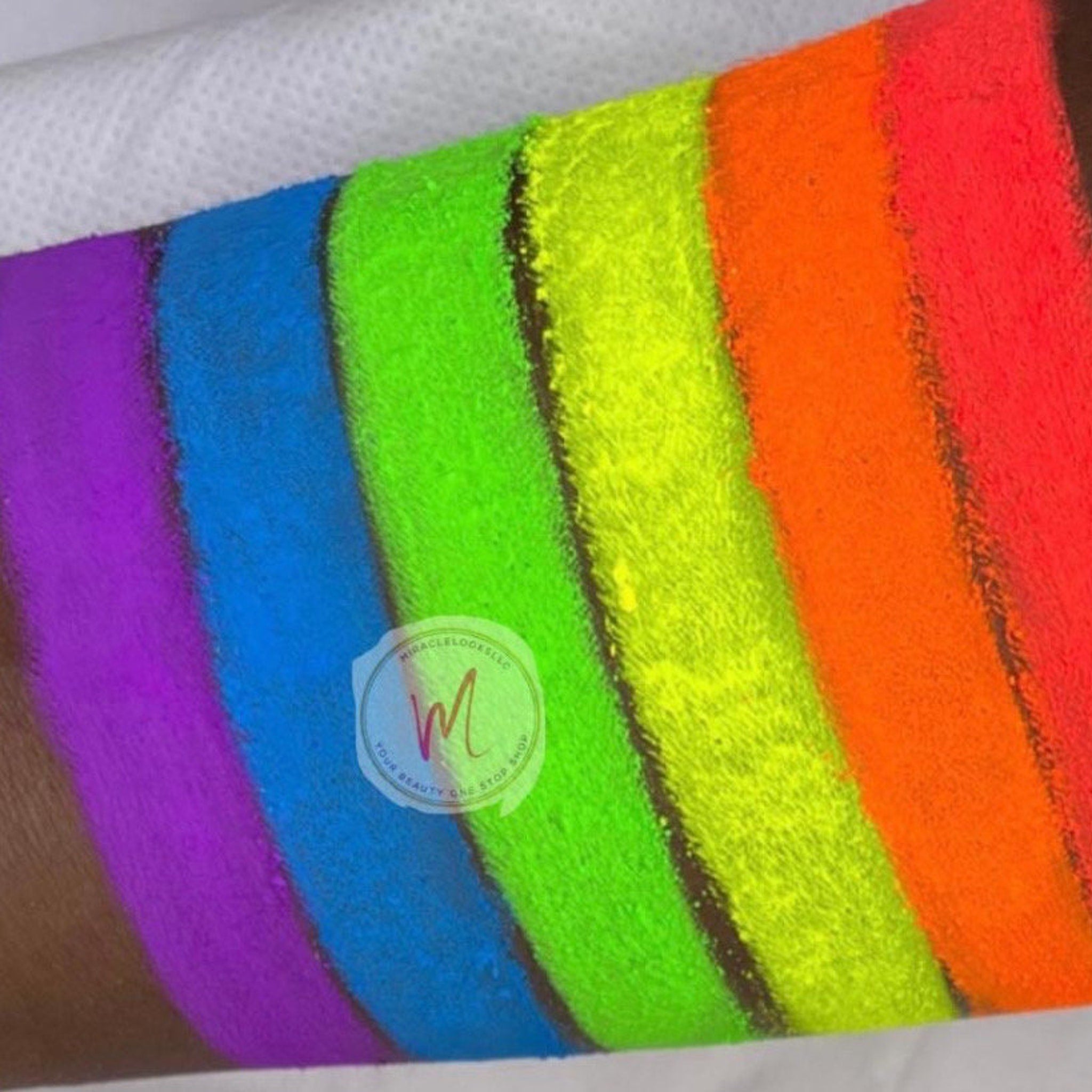 Hand applying vibrant neon pink matte eyeshadow with fingertip to eyelid, showcasing bold pigment payoff