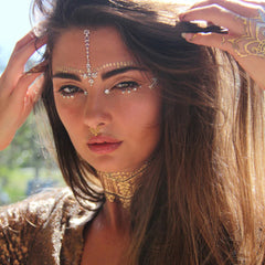 Face jewels with gold and silver metallic temporary tattoos on model's face and hand