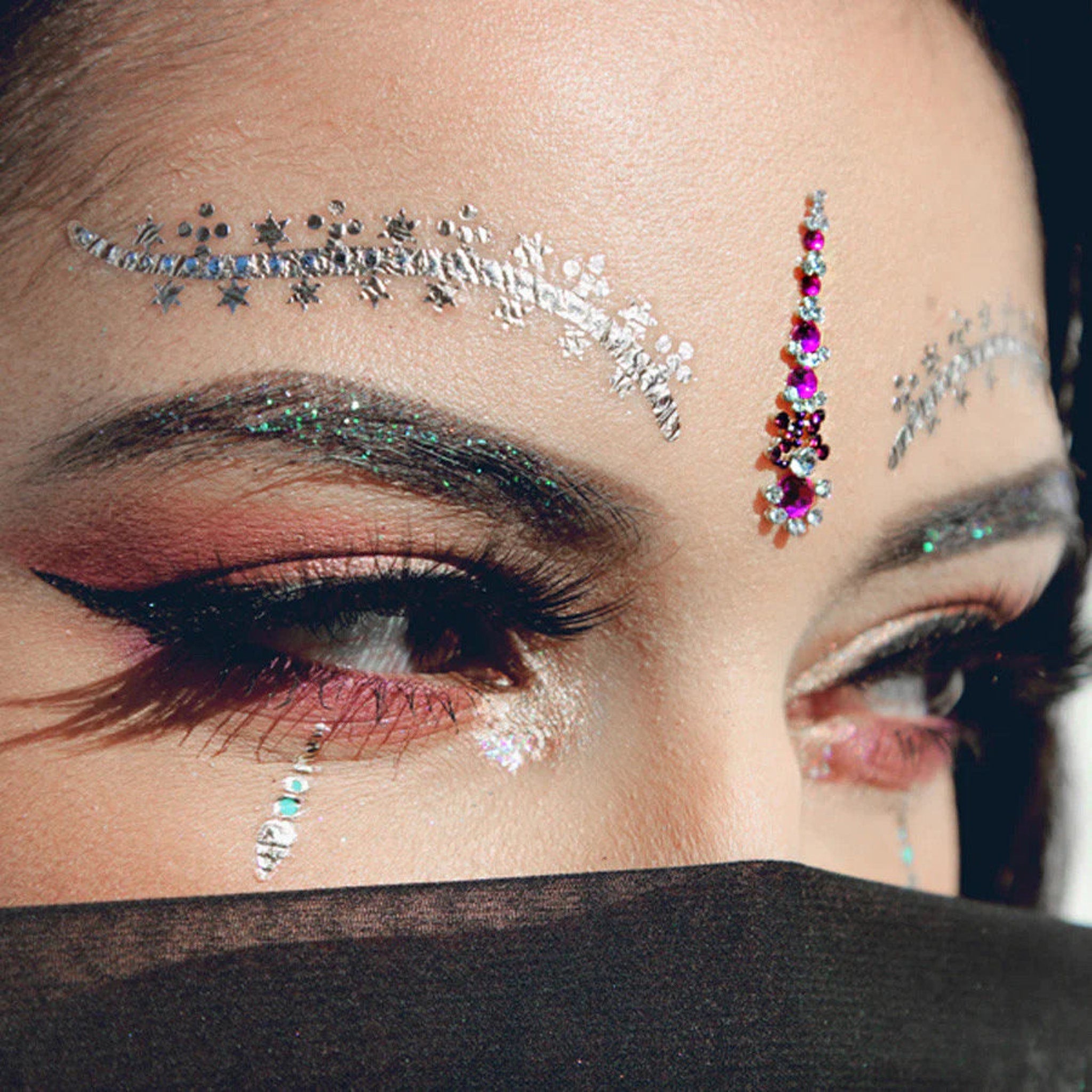 Face jewels with silver and pink gems, applied on the forehead and under the eye, with eye makeup