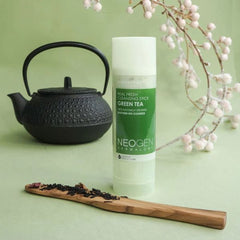 Facial Cleanser stick with green and white label, NEOGEN DERMALOGY branding, next to a black teapot