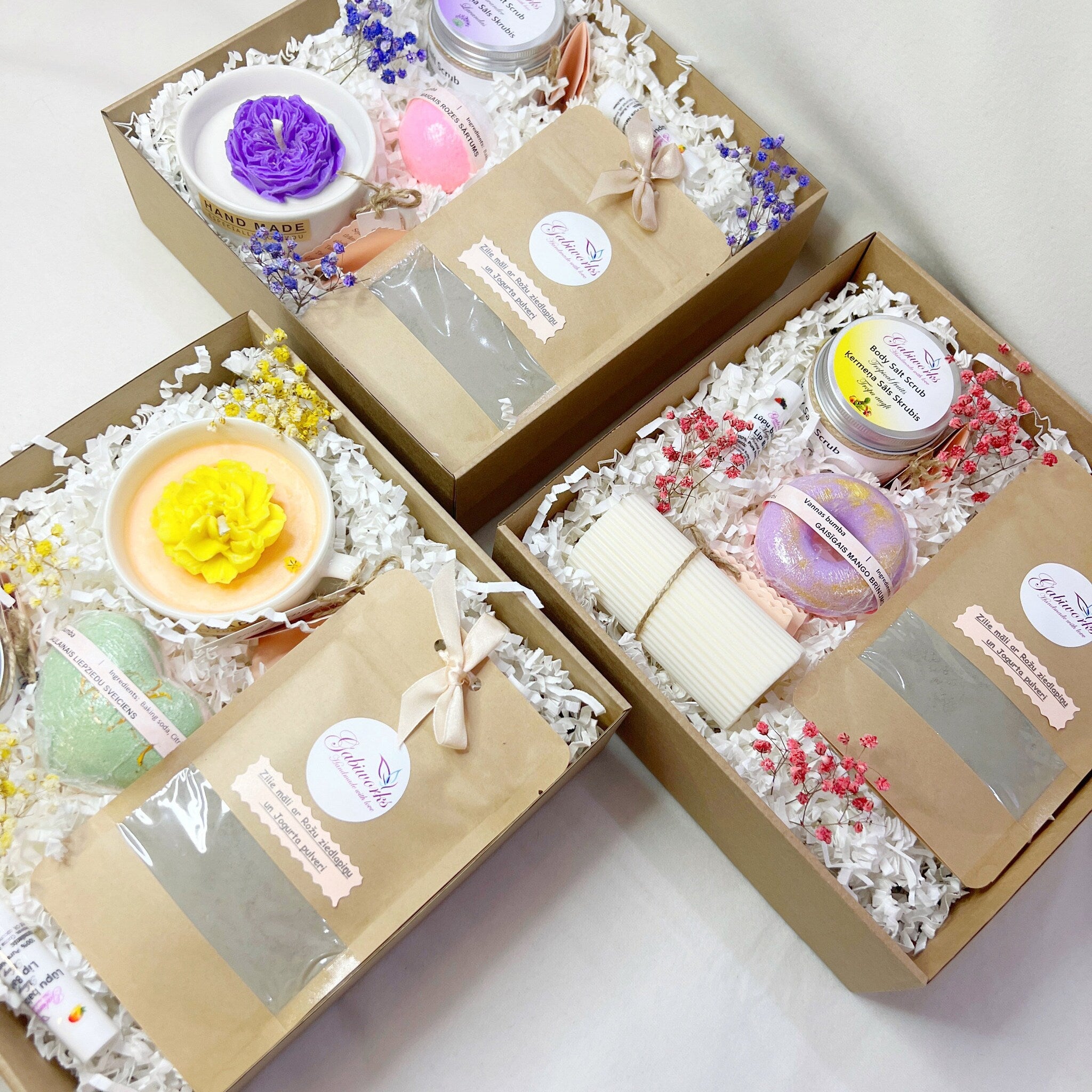 Gift boxes with candles, bath bombs, and Gabiworks branding, arranged with decorative paper