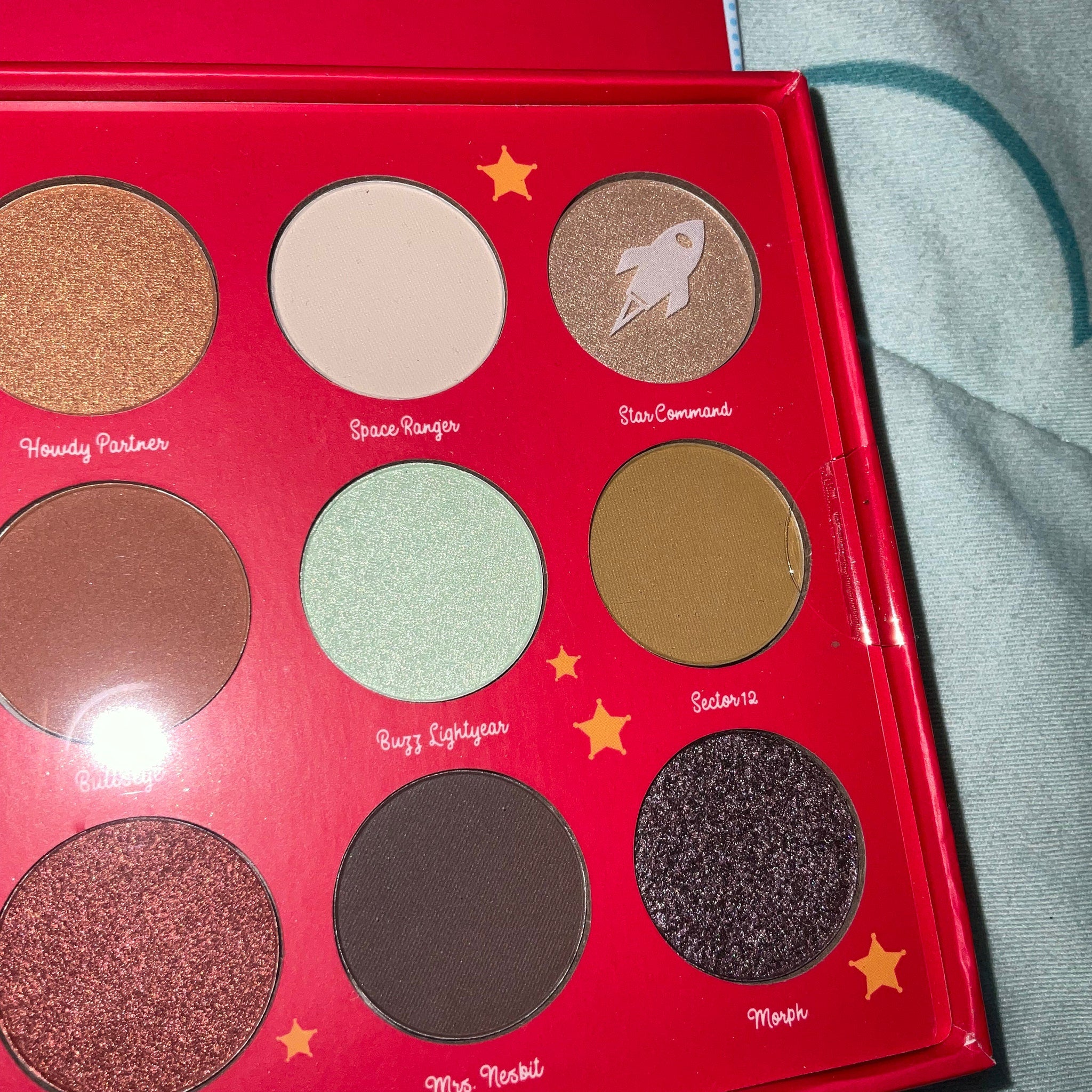 Toy Story eyeshadow palette open with colorful matte and shimmer shades featuring Woody and Buzz Lightyear designs