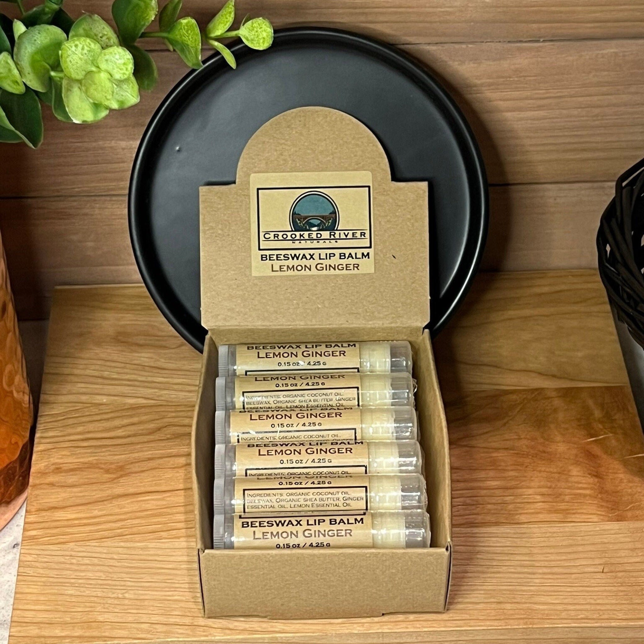 Beeswax lip balm tubes in clear plastic, with brown labels, in a cardboard box, Crooked River Naturals brand
