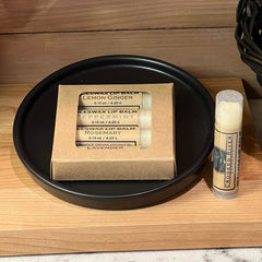 Beeswax lip balm collection in a black dish with Crooked River Naturals label and cardboard packaging