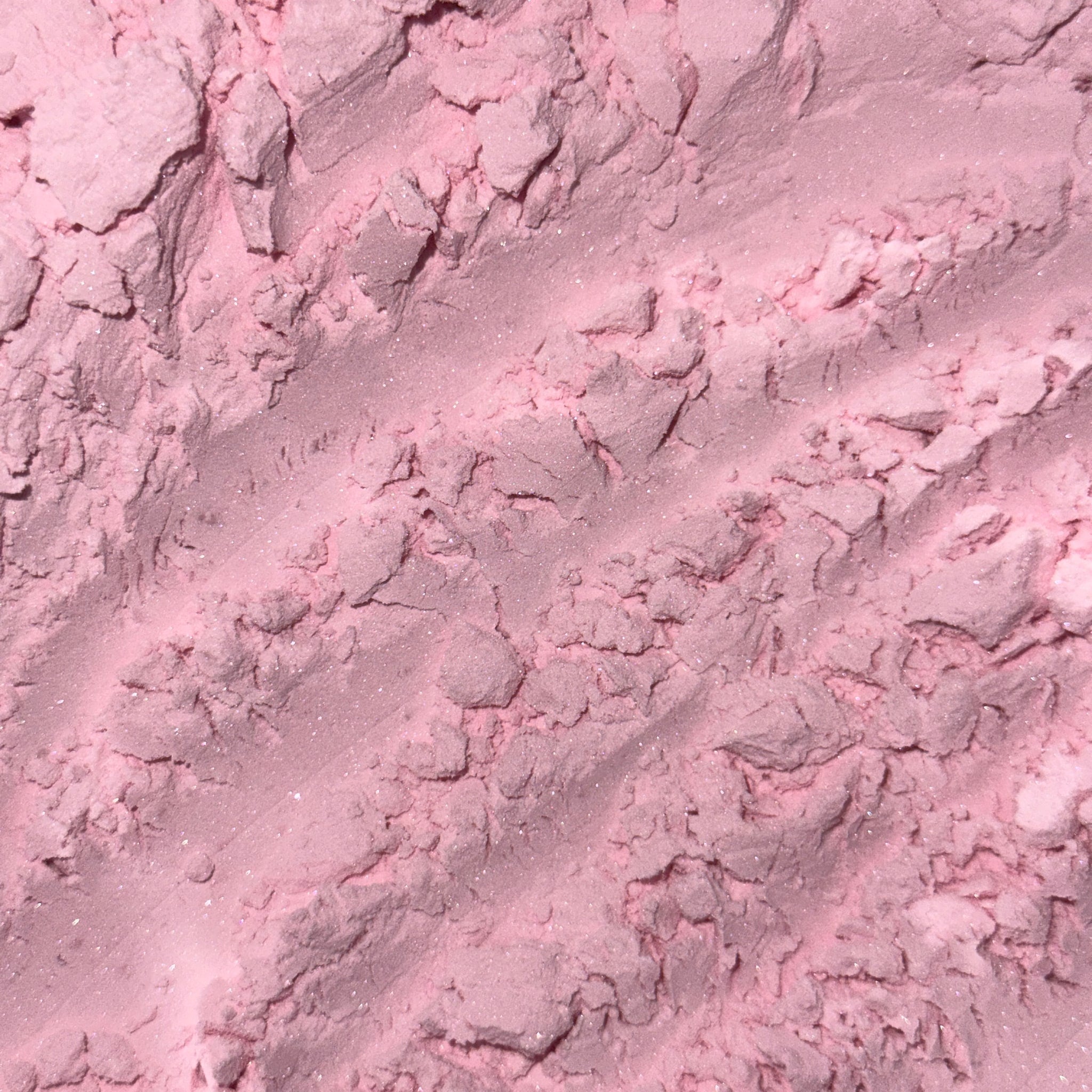 Pink powder with textured surface and subtle glitter detail, close-up view