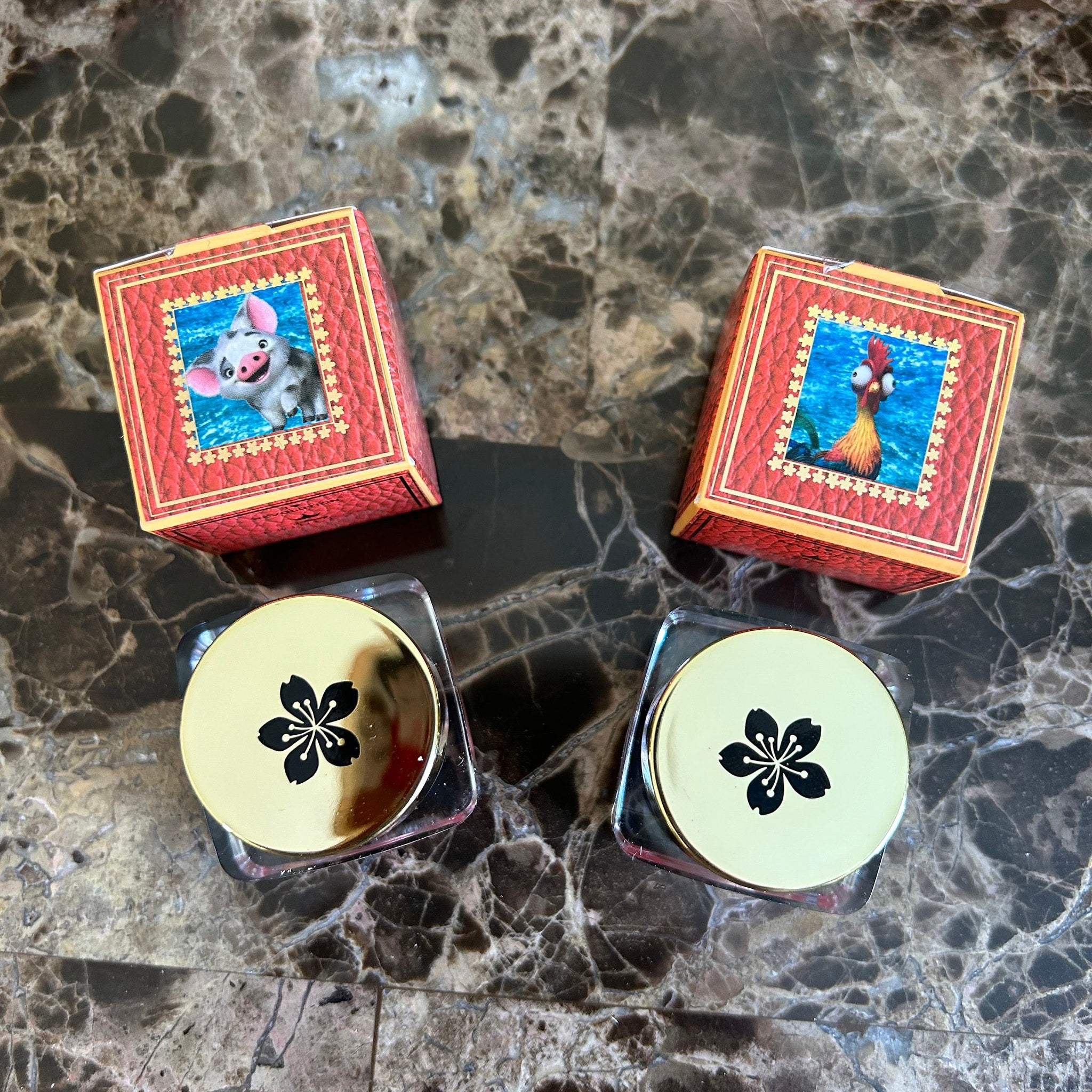 Boxes with character images, red textured, gold trim, and gold lids with black flower design