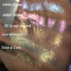Close-up of five multichrome pressed eyeshadows with shimmery sparkle and color-shifting hues in a palette