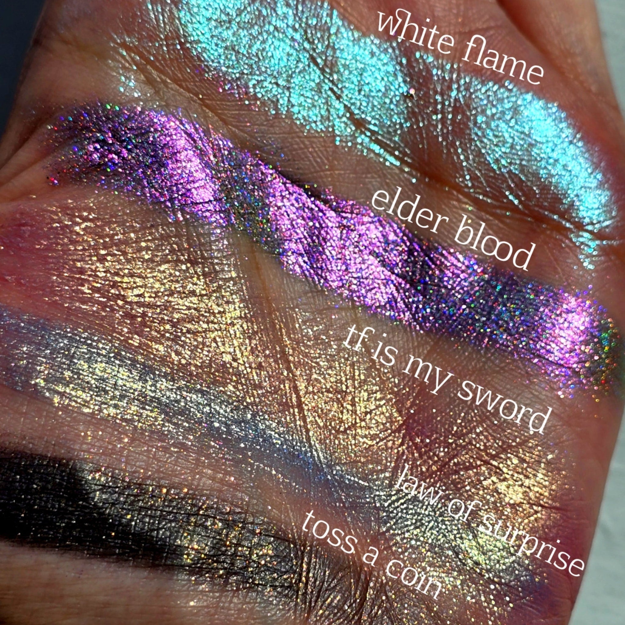 Close-up of pressed multichrome eyeshadow pan shimmering with color-shifting green, gold, and purple hues