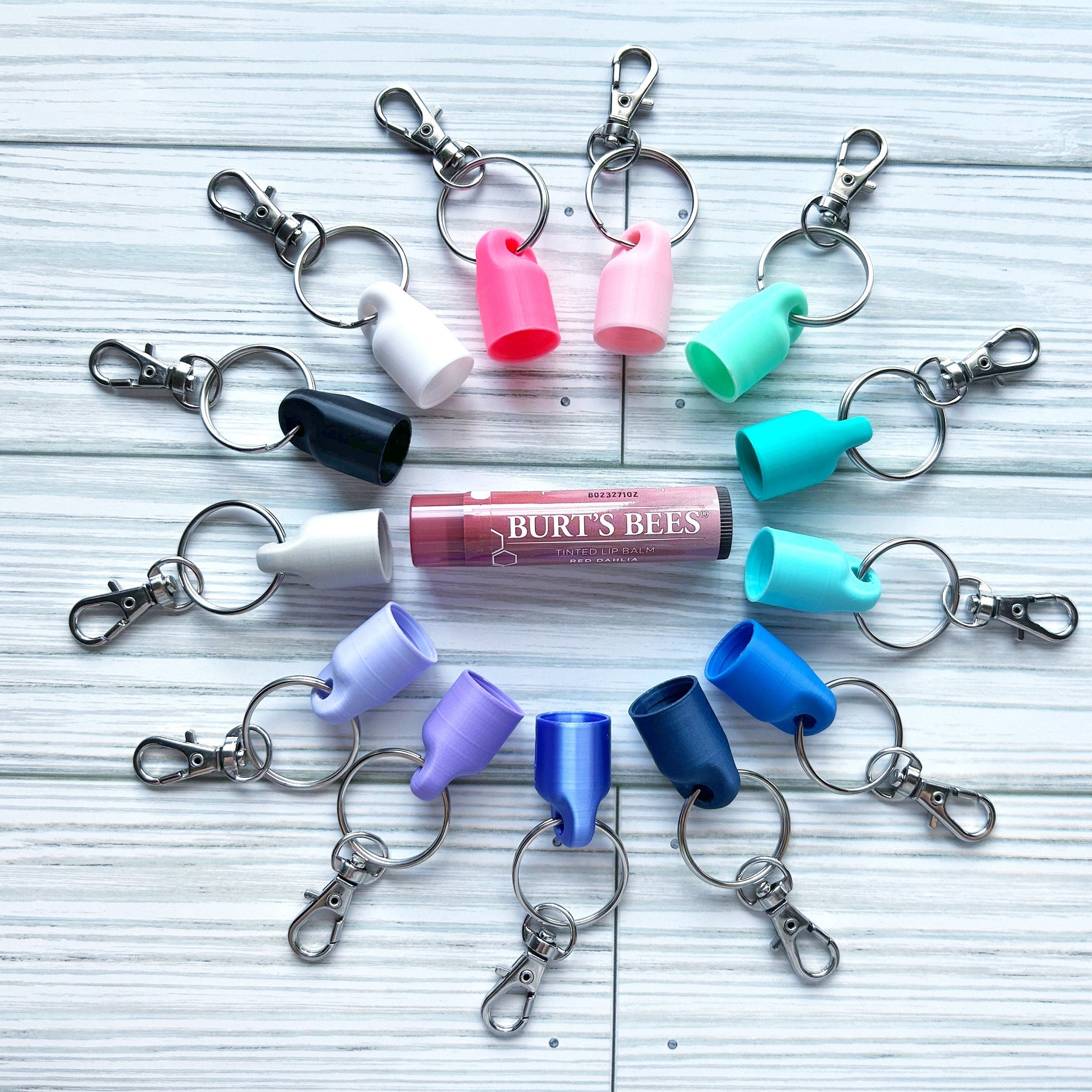 Lip balm holders with various colors, key rings, and Burt's Bees lip balm in center