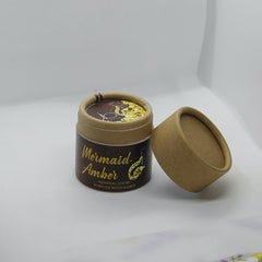Mineral loose powder in brown and tan cardboard tube with Mermaid Amber text and lid off