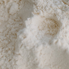 Flour close-up, off-white powder with textured surface and visible granules