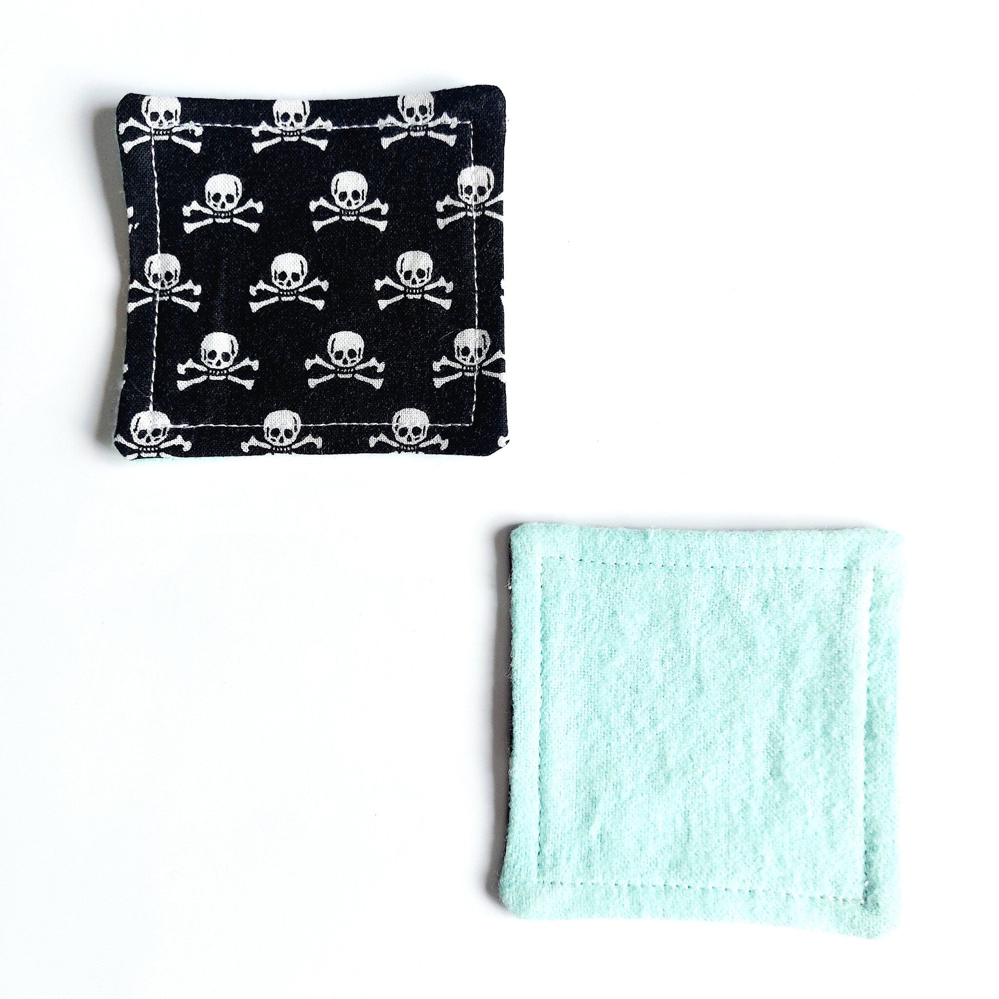 Reusable facial rounds with black skull print and mint green fabric, square shape