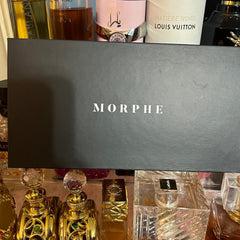 Open Morphe eyeshadow palette displaying 12 vibrant matte and shimmer shades in a sleek black case