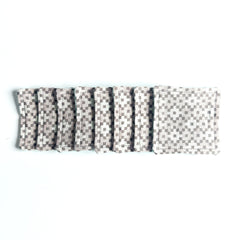 Coasters with gray and white checkered pattern, stitched edges, stacked on white surface