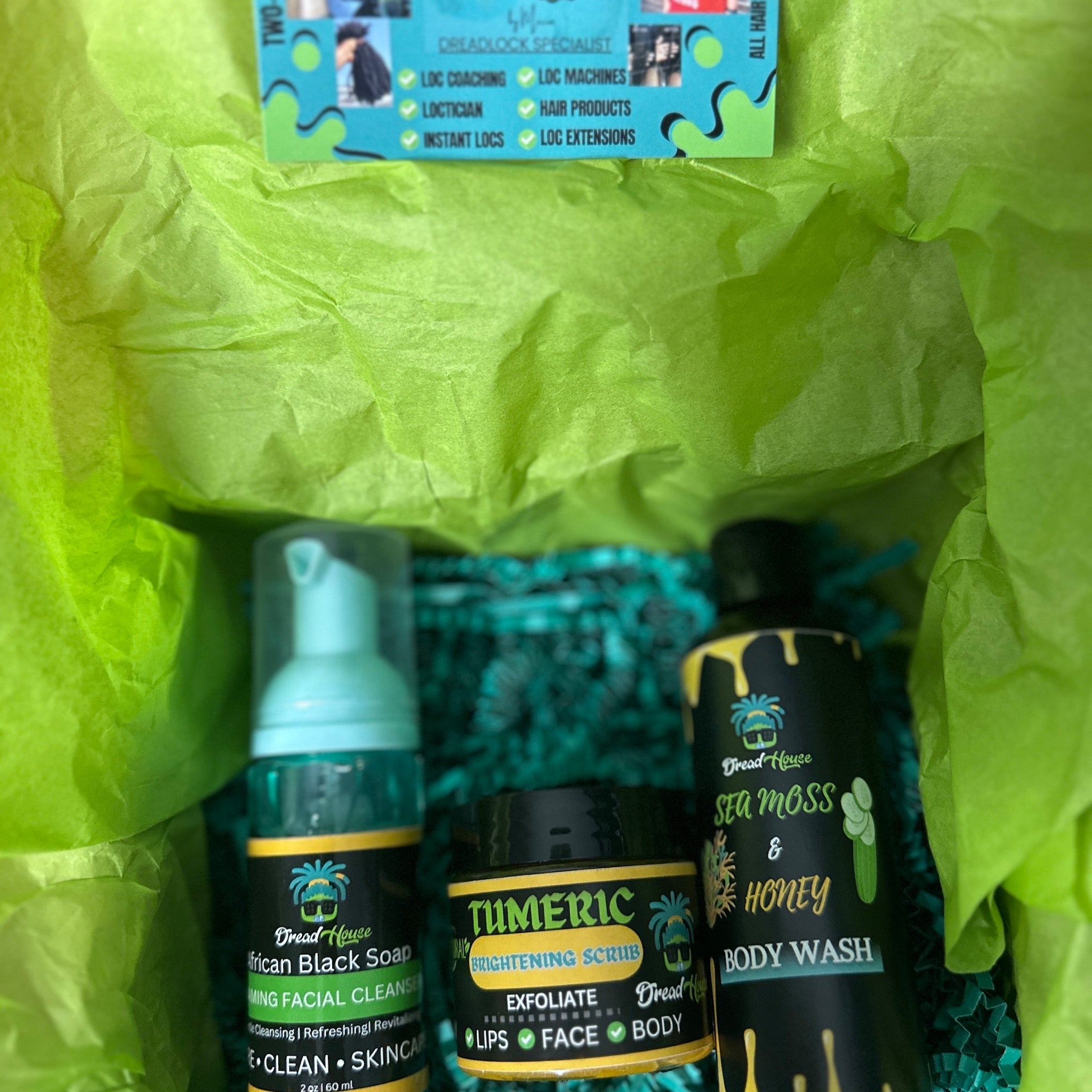 Skincare products in a gift box with green tissue paper, various bottles and jars of Dread House brand products