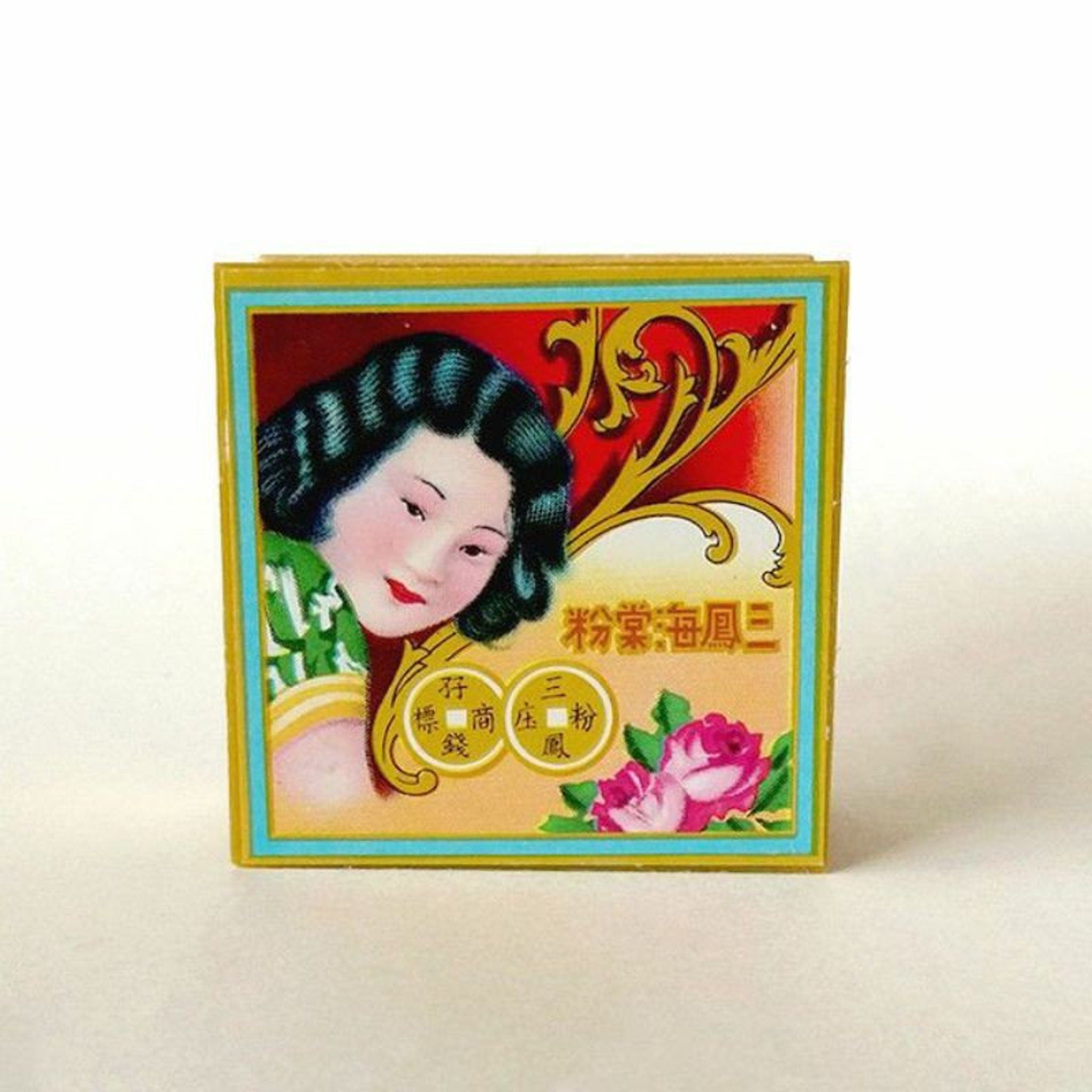 Vintage cosmetic box with woman illustration, red and gold frame, floral accents, and Chinese text