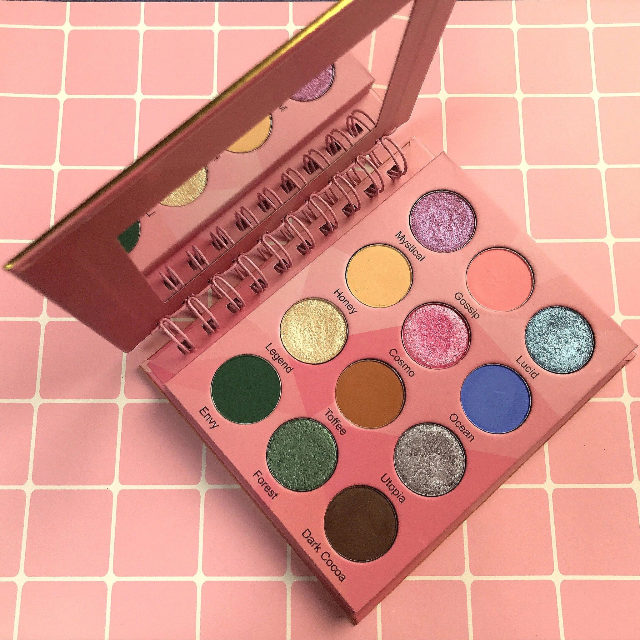 Lavish Beauty London eyeshadow palette with 12 vibrant shades in a sleek black compact, open to display colorful matte and shimmer pans
