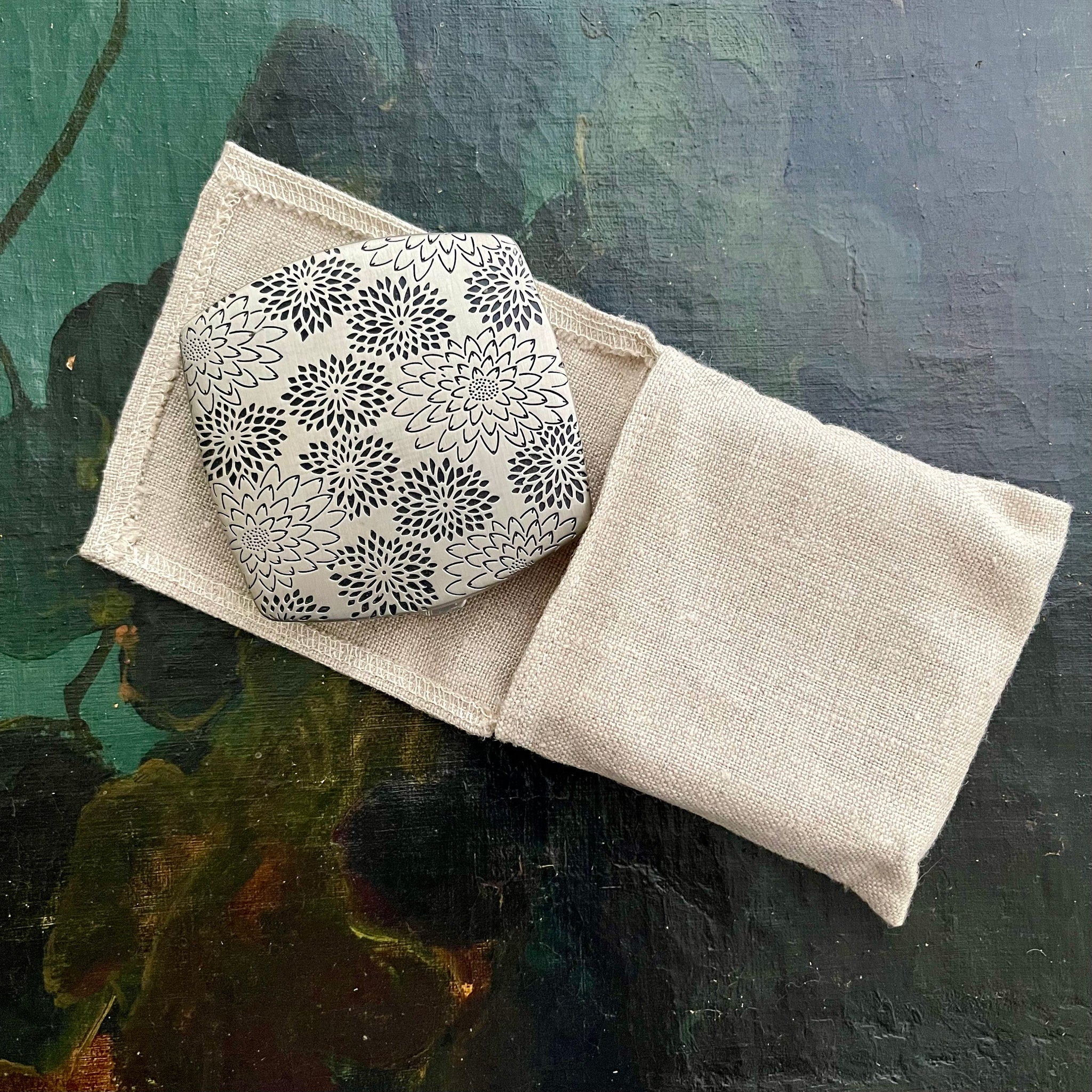 Floral patterned object in a linen pouch, beige linen, black and white floral pattern