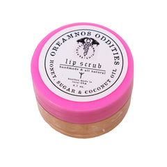 Close-up of all-natural lip scrub in round glass jar with wooden scoop on textured fabric