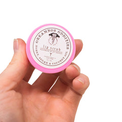 Close-up of natural lip scrub being gently applied to lips with a fingertip for smooth exfoliation