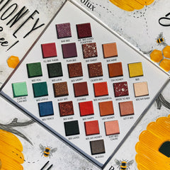 Eyeshadow palette with multiple square pans in various colors and textures, "olux" brand name visible