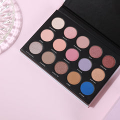 Eyeshadow palette with multiple colors including pink, brown, and blue, in a black compact case