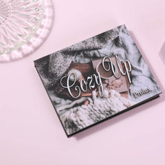 Cozy Up book with black cover, white script text, and Prolux brand name on pink background